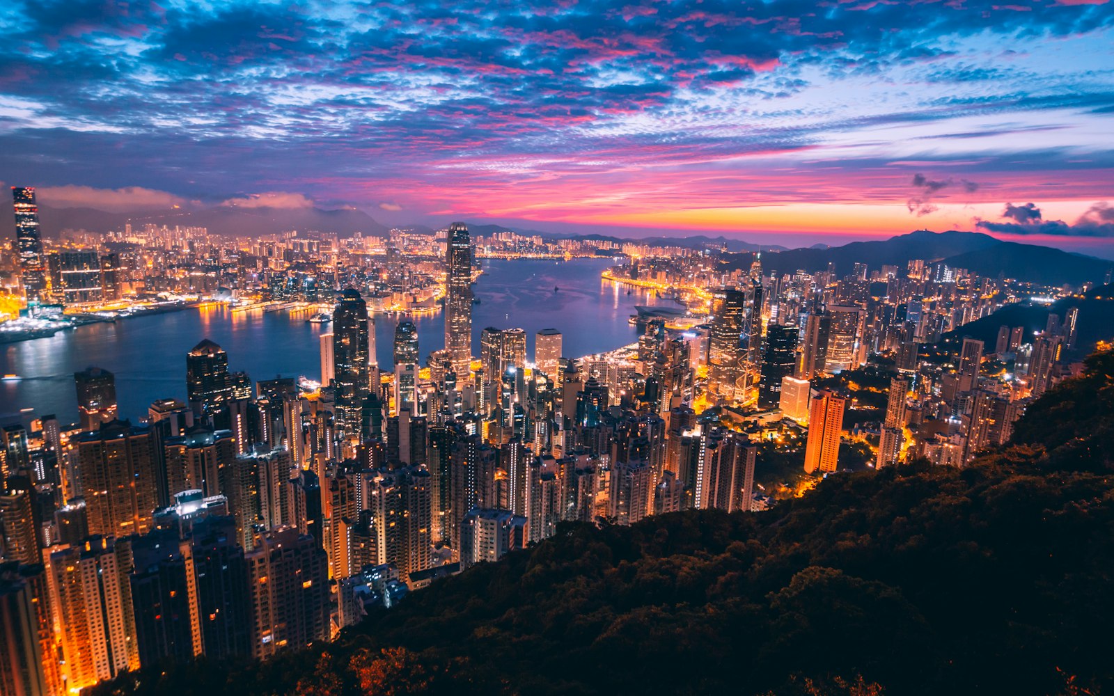Couple admiring Hong Kong skyline view from Victoria Peak at sunset