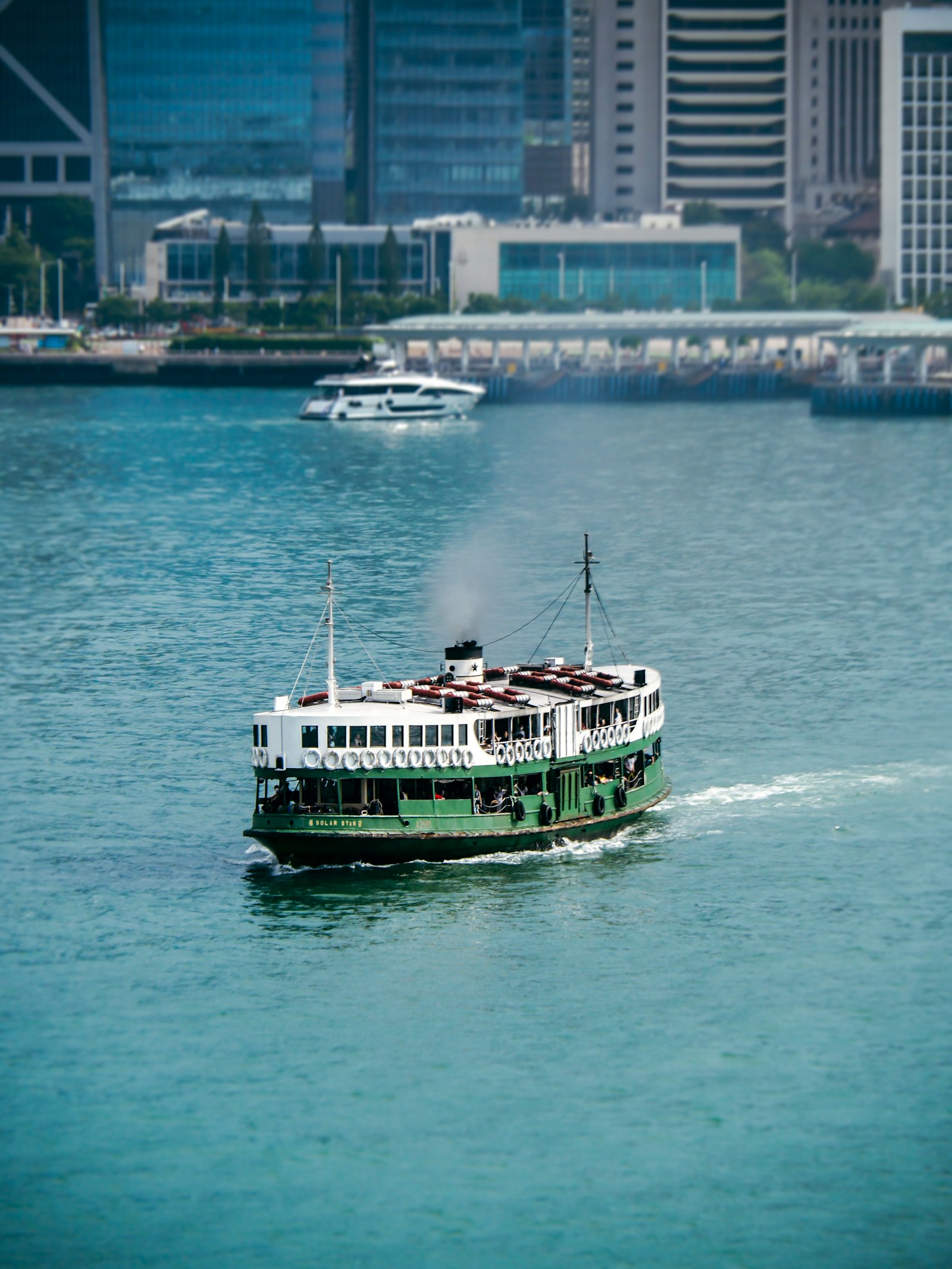 Couple riding the Star Ferry across Victoria Harbour with Hong Kong Island skyline behind them
