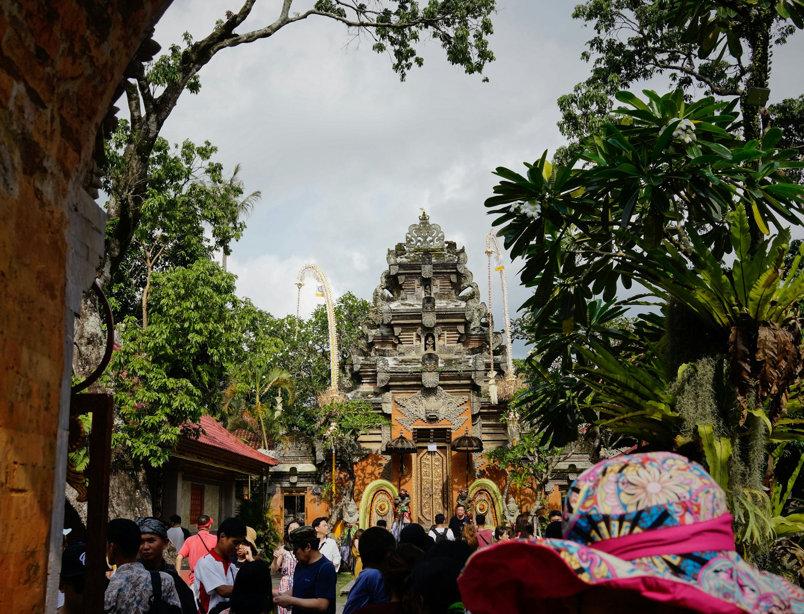 Couple walking through the ornate stone gate of Ubud Palace at sunrise